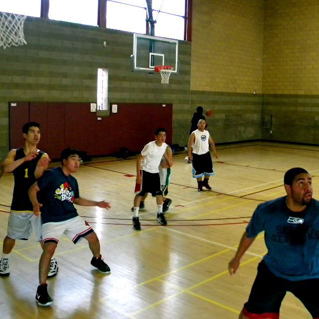 Young men playing basketball in an indoor gym 1
