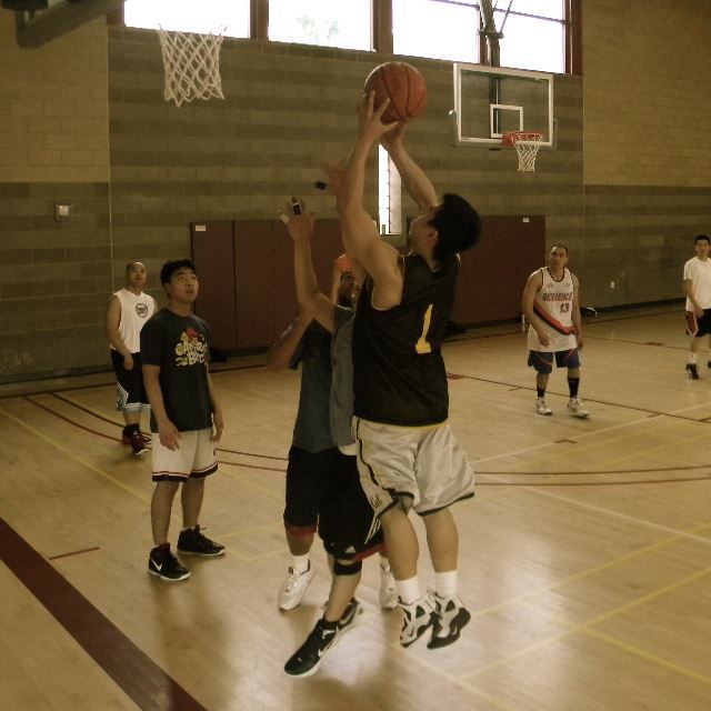 Young men playing basketball in an indoor gym 2