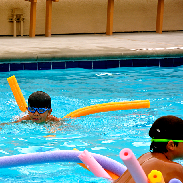 Kids in the pool with pool noodles 1