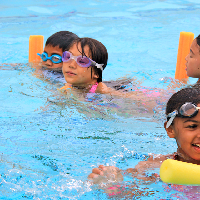 Kids in the pool with pool noodles 2