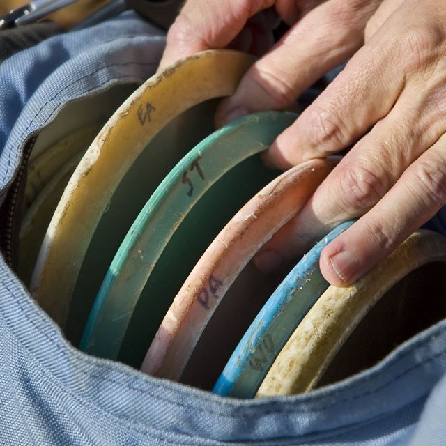 Person grabbing discs from a bag