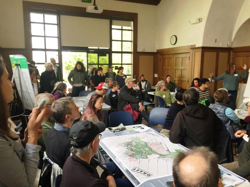 Grupo de personas sentadas en varias mesas con mapas