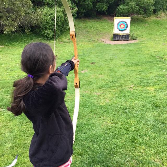 女孩张弓向靶子射箭
